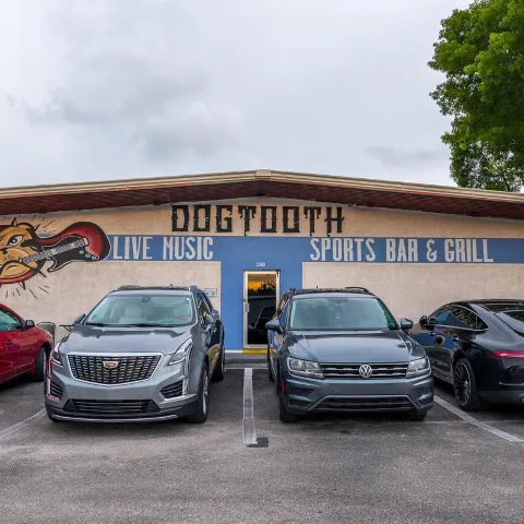Exterior, storefront with signage, entrance and a parking lot.