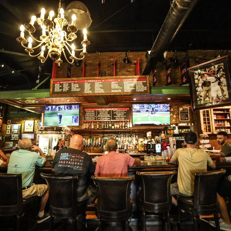 Interior, guests sitting at a bar counter, back view.