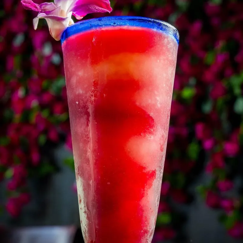Frozen Sangria served with in a pint glass, topped with a flower.