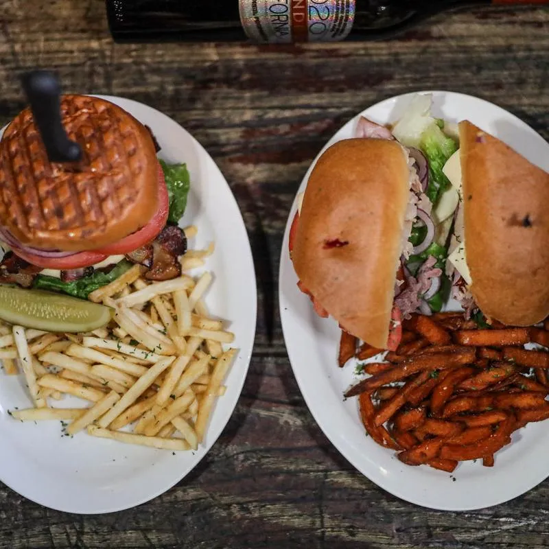 Cheeseburger  and buffalo chicken sandwich, served with  fries, top view.