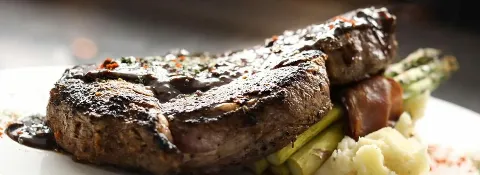 Bone-In Ribeye Steak with bacon-wrapped asparagus and mashed potatoes