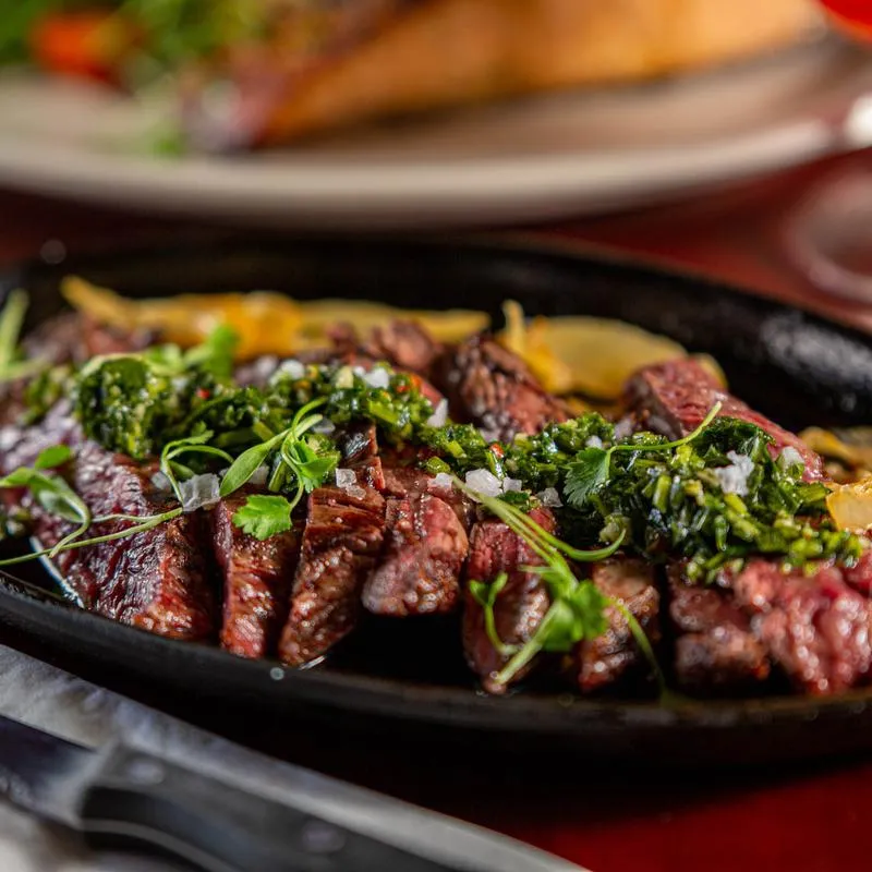 Skirt steak served with chimichurri.