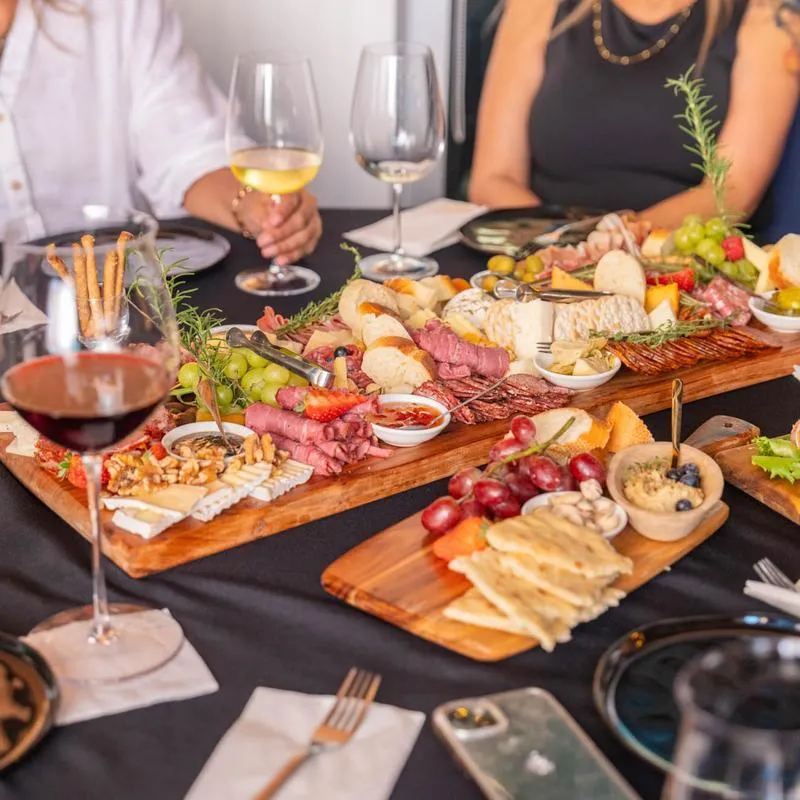 Charcuterie board and wine glasses served to a group of guests.