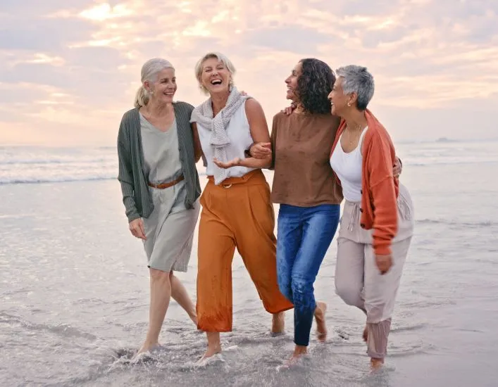 A Group Of People Walking On A Beach