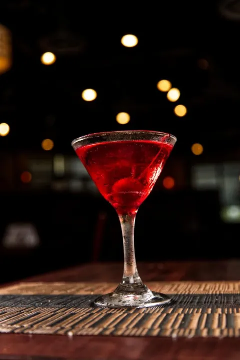 Pomegranate peach martini glowing against the bar lights