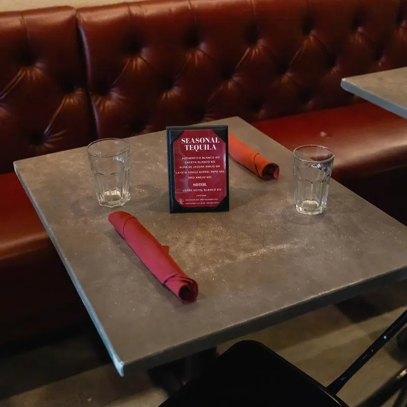 Table with rolled napkins and glasses.