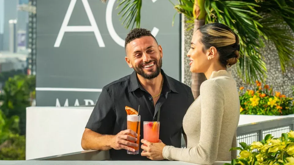A Man And Woman Holding Drinks
