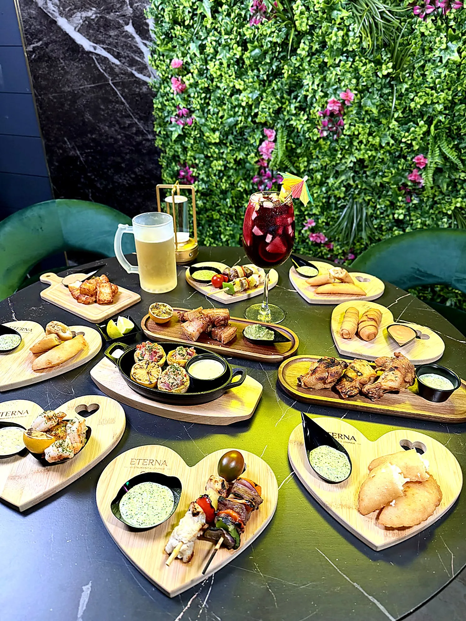 Tapas spread on heart-shaped Eterna boards with sangria and draft beer against the flower wall