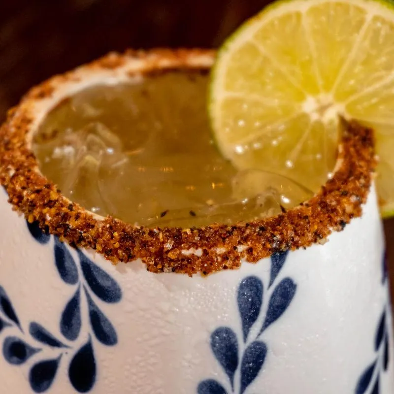 Clase Azul Margarita in a white and blue mug, spiced rim, lime wheel , close up