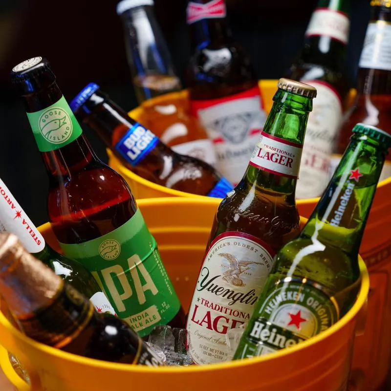 Couple of ice buckets filled with vaious bottles of beer.