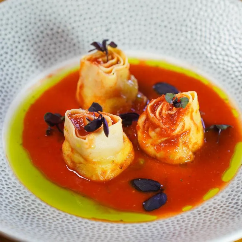 Stuffed rose shaped pasta in red and green sauce.