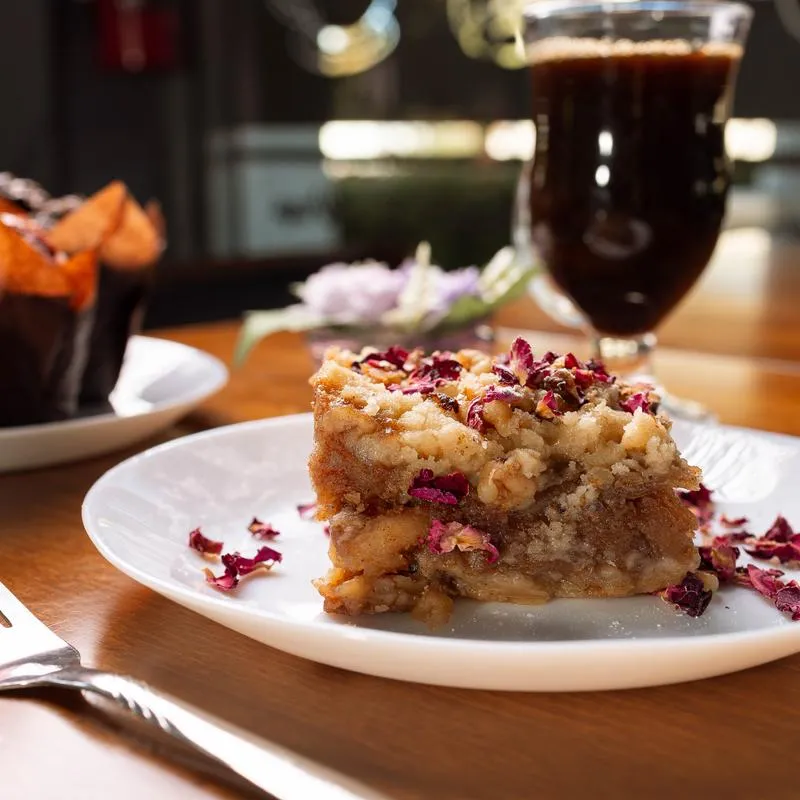 Homemade Apple Crumble pie served on the table with black coffee.