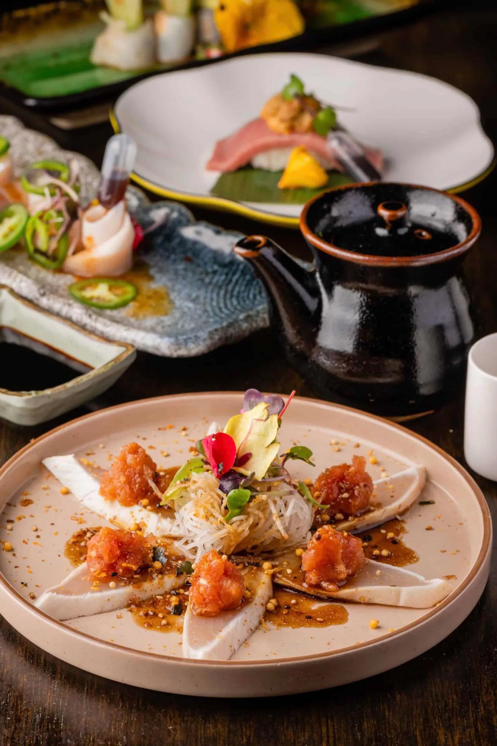 Table spread with a variety of fresh sashimi and Japanese dishes