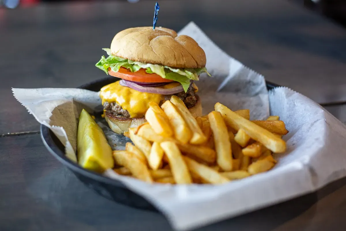 A hamburger and french fries on a plate on a table.