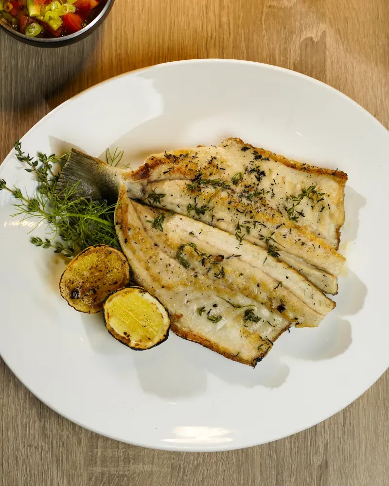 A white plate topped with fish and vegetables.