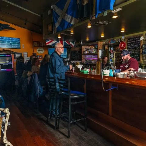 Interior, patrons gathered at a bar.