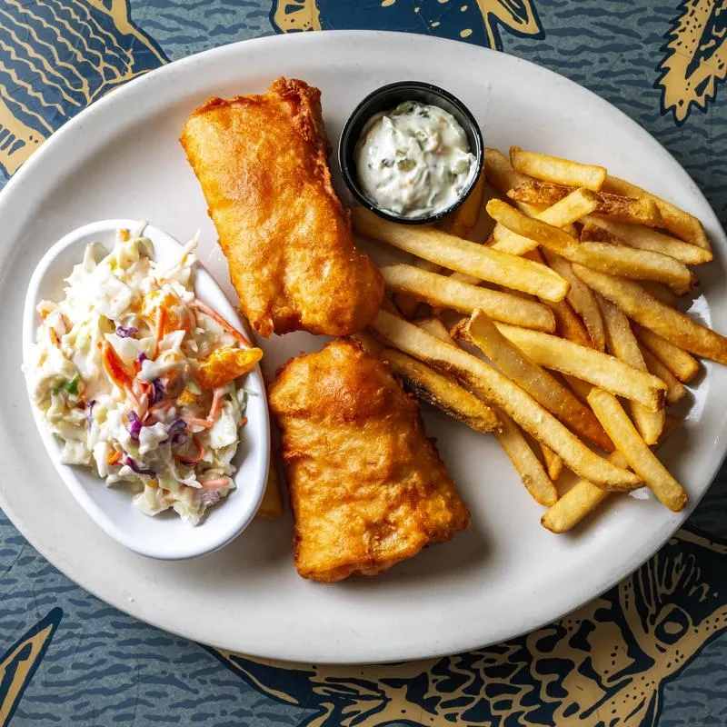 Fried fish with side of fries and coleslaw.