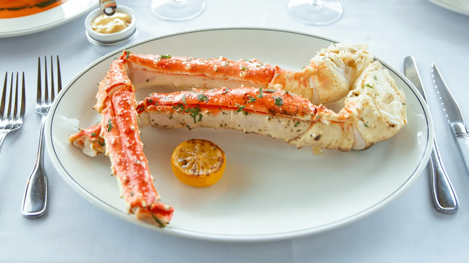 picture of Alaskan king crab legs on a plate with a lemon wheel