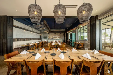 Rustic private dining room with long tables set.