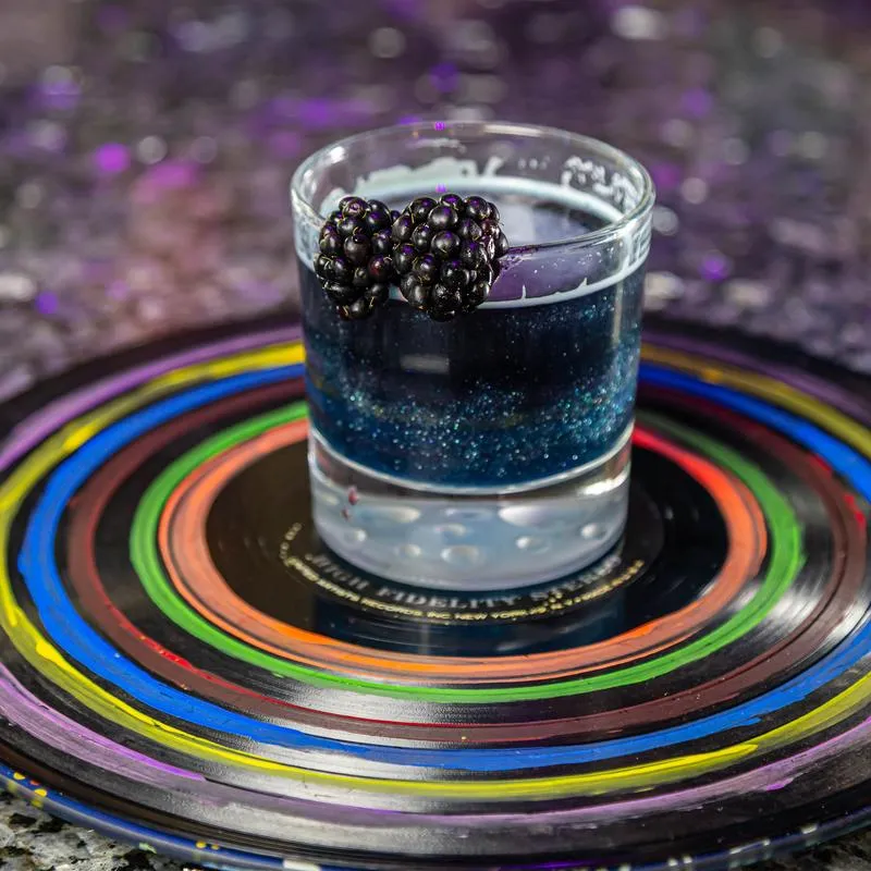 Star Dust drink garnished with fresh blackberries and served.