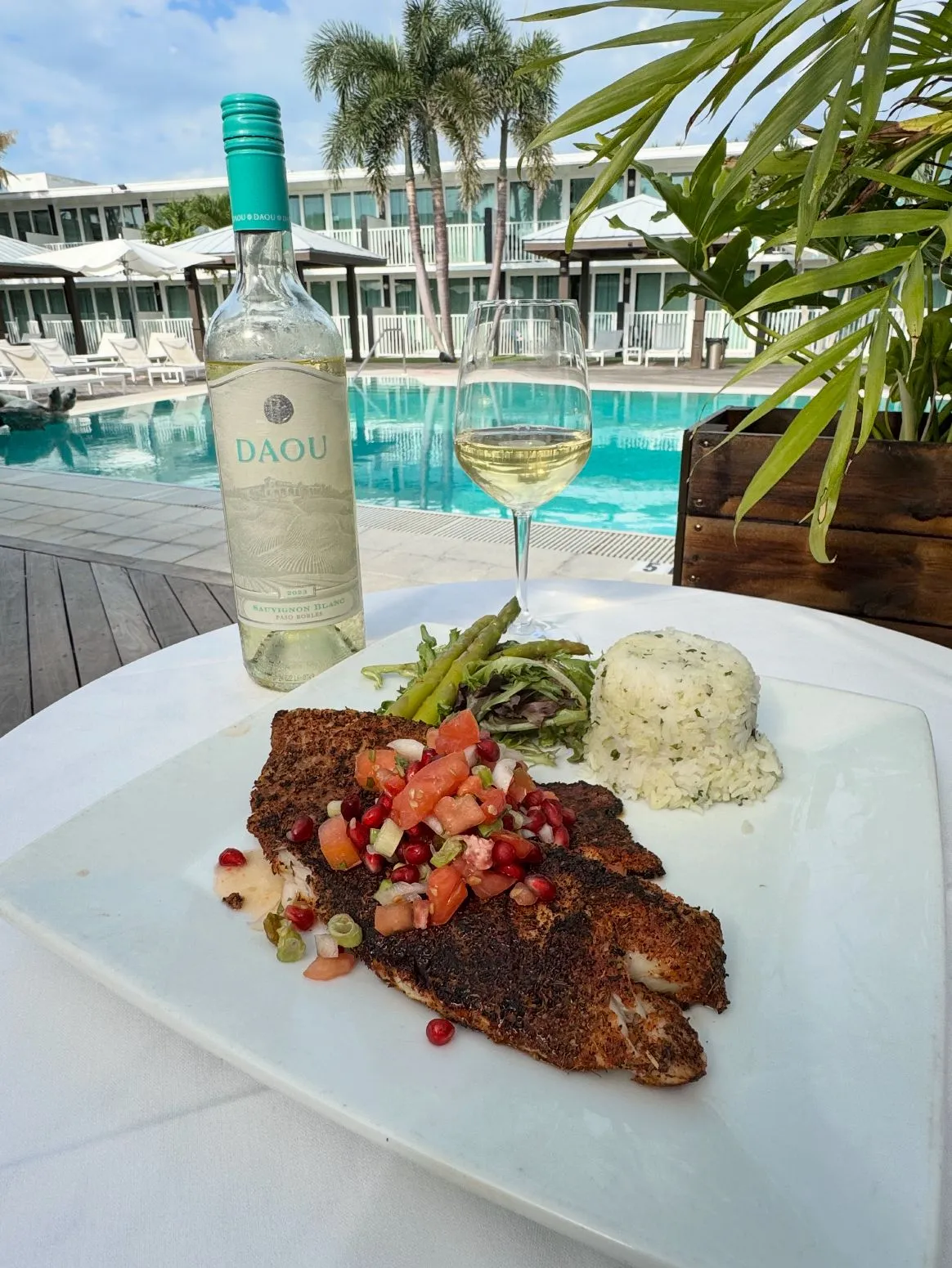 tilapia and glass of wine with pool in background osprey, fl