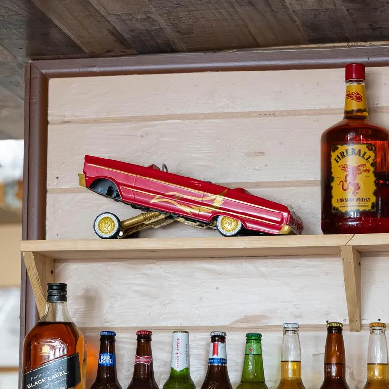 Model car and a whisky bottle on the shelf.