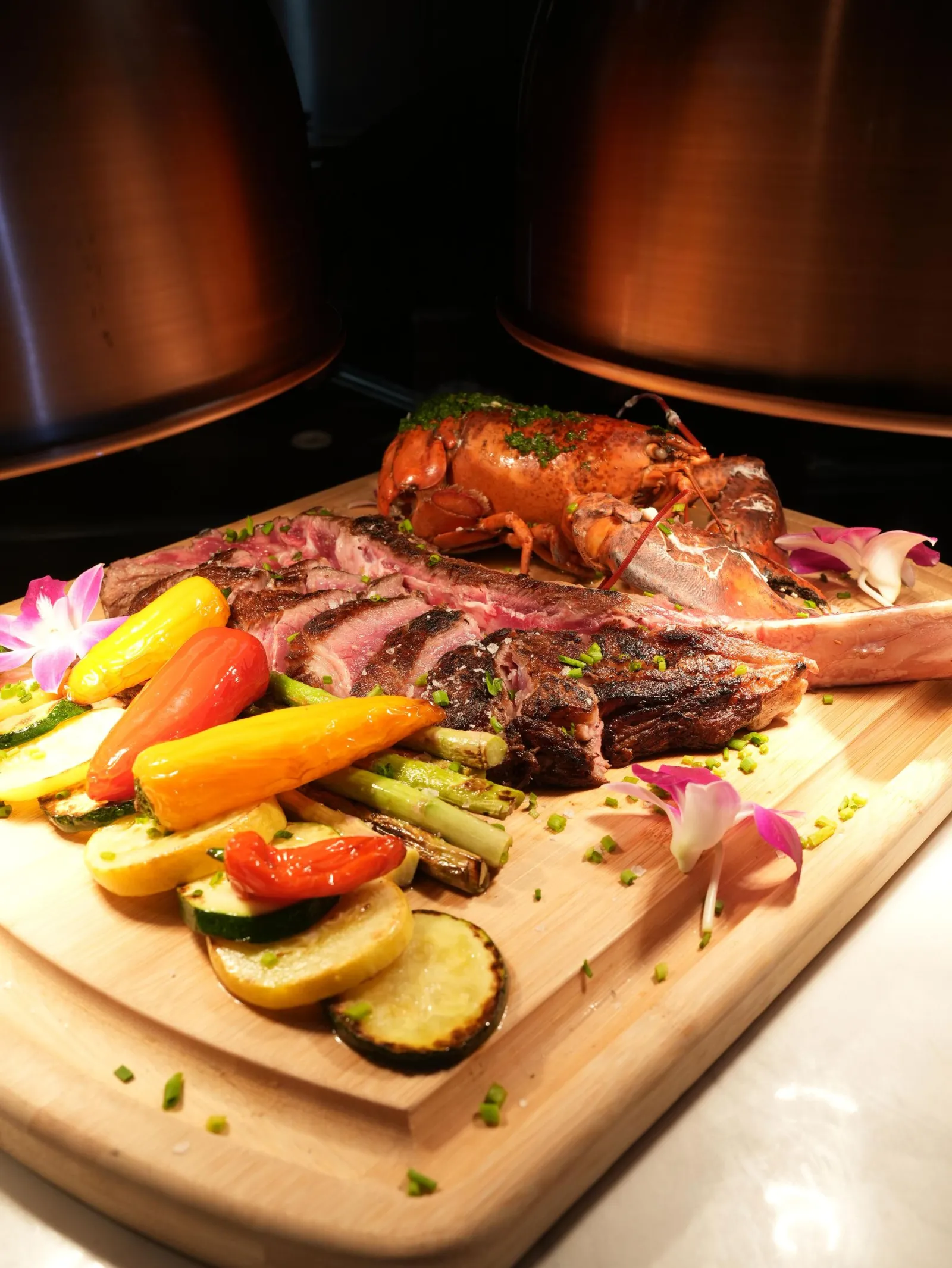 Sharing board with grilled entraña, whole lobster and roasted vegetables at Madrid Tapas y Vinos