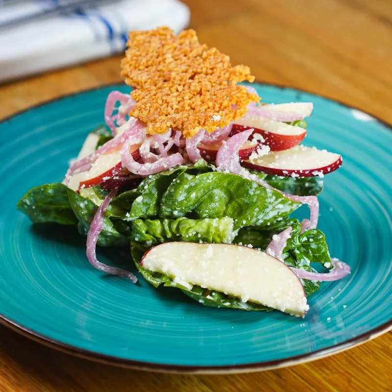Salad with fresh greens, apples, red onions, and parmesan crisp.