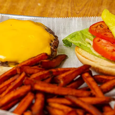 Angus cheeseburger with sweet potato fries on the side.