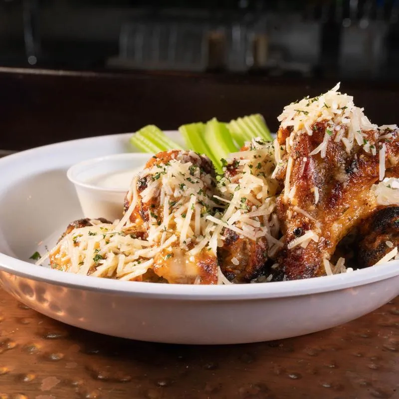 Fried chicken wings, covered in garlic parmesan, with celery and ranch dressing.