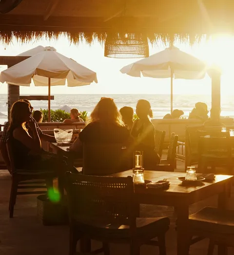 People dining at an outdoor restaurant oceanside