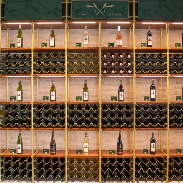 A row of wine bottles on a wooden shelf.