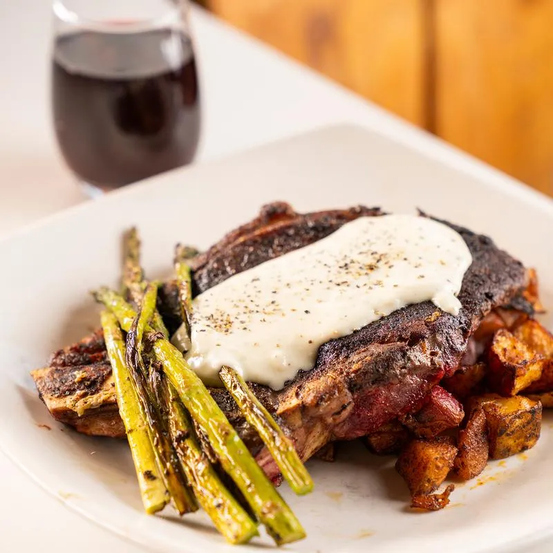 Grilled Ribeye steak with sides of potatoes and asparagus.