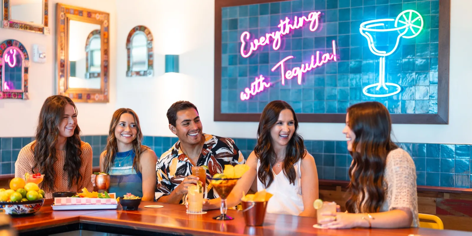A Group Of People Sitting At A Bar