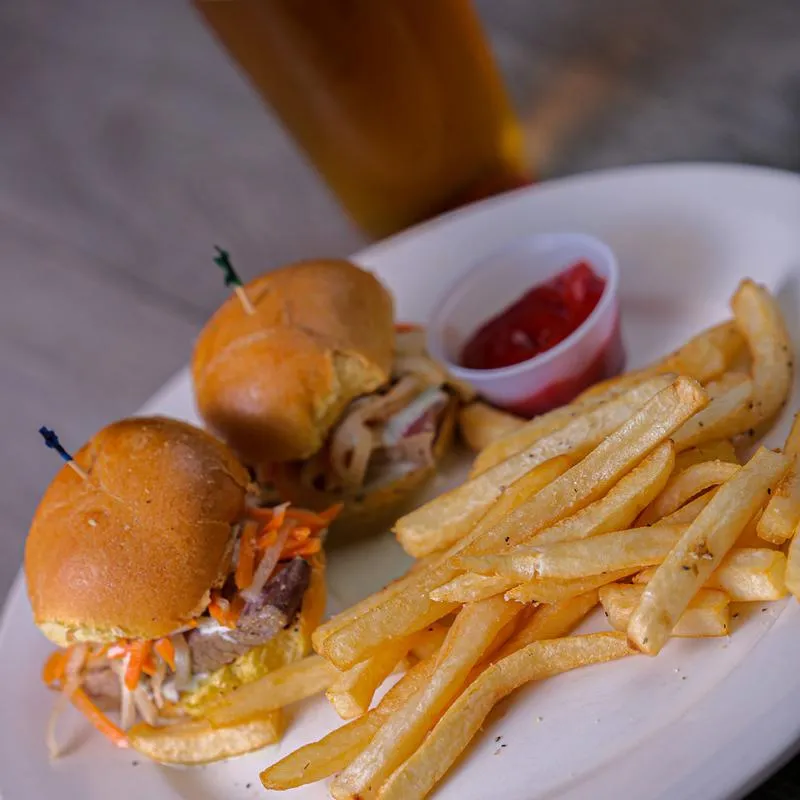 Two burgers, fries and dip on the side.