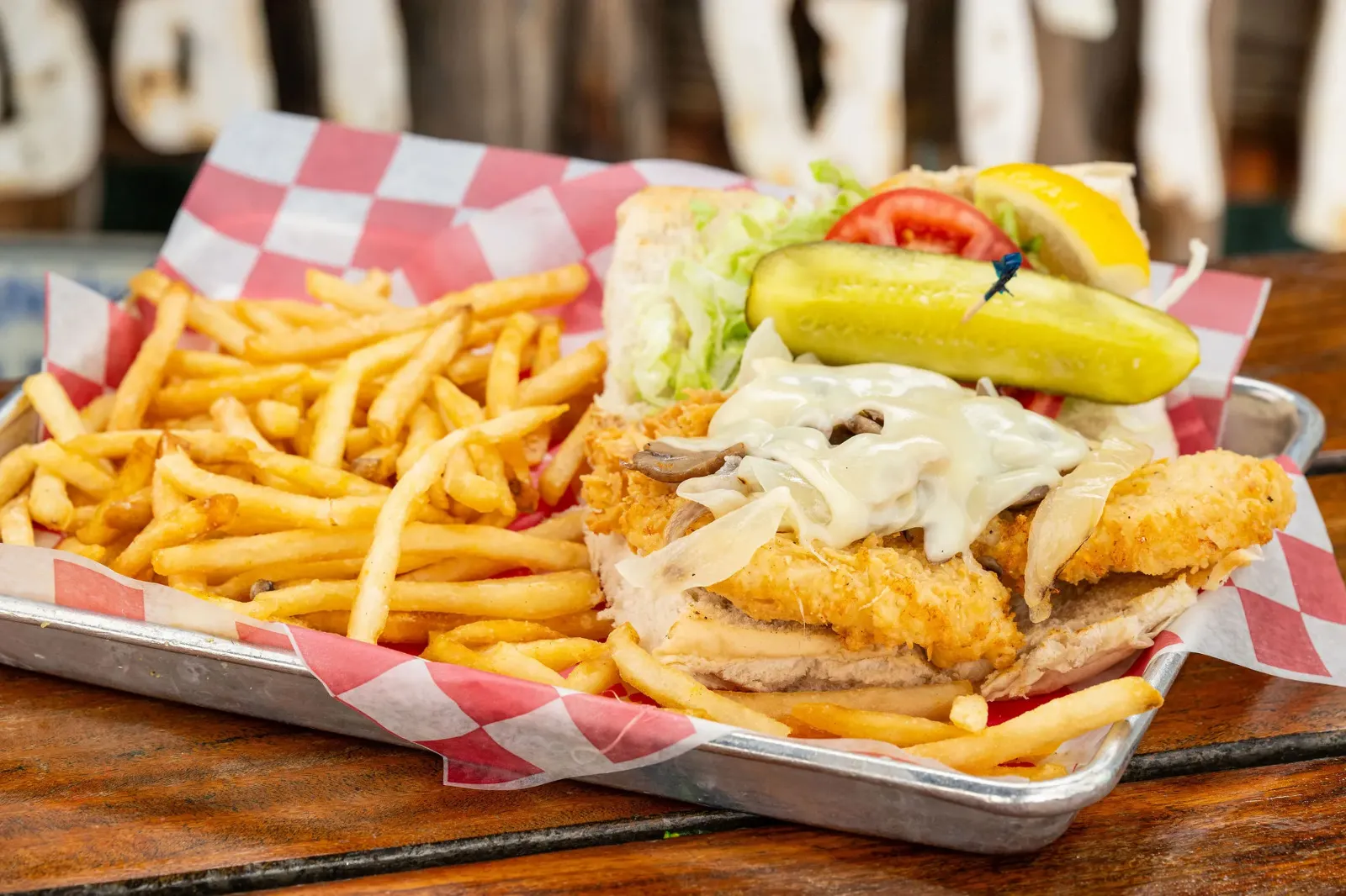 Our fried hogfish sandwich smothered with Swiss cheese, onions and mushrooms, with fries and a pickle