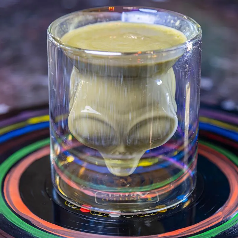 Matcha Tea served in a glass shaped like an alien head.