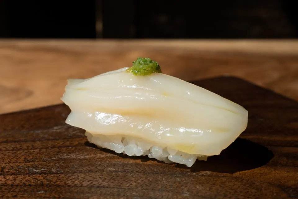 nama hotate sushi served on a wooden plate at uchi miami