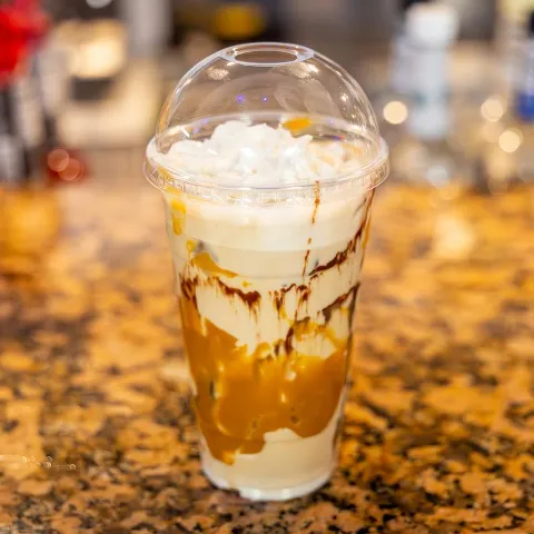 Frozen Ice Coffee served in a clear cup on a bar counter.