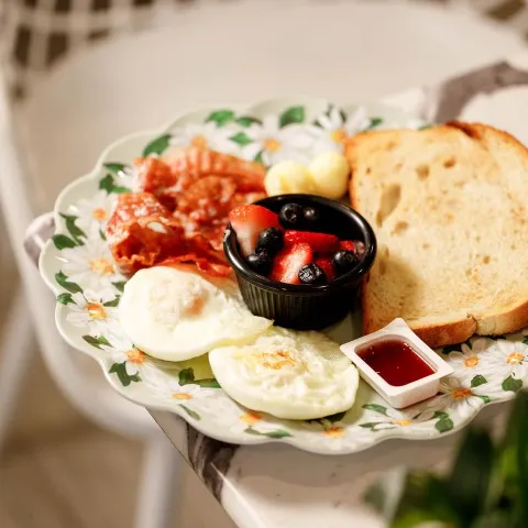 Breakfast Platter with fried eggs, bacon, toast, jam and fresh berries.