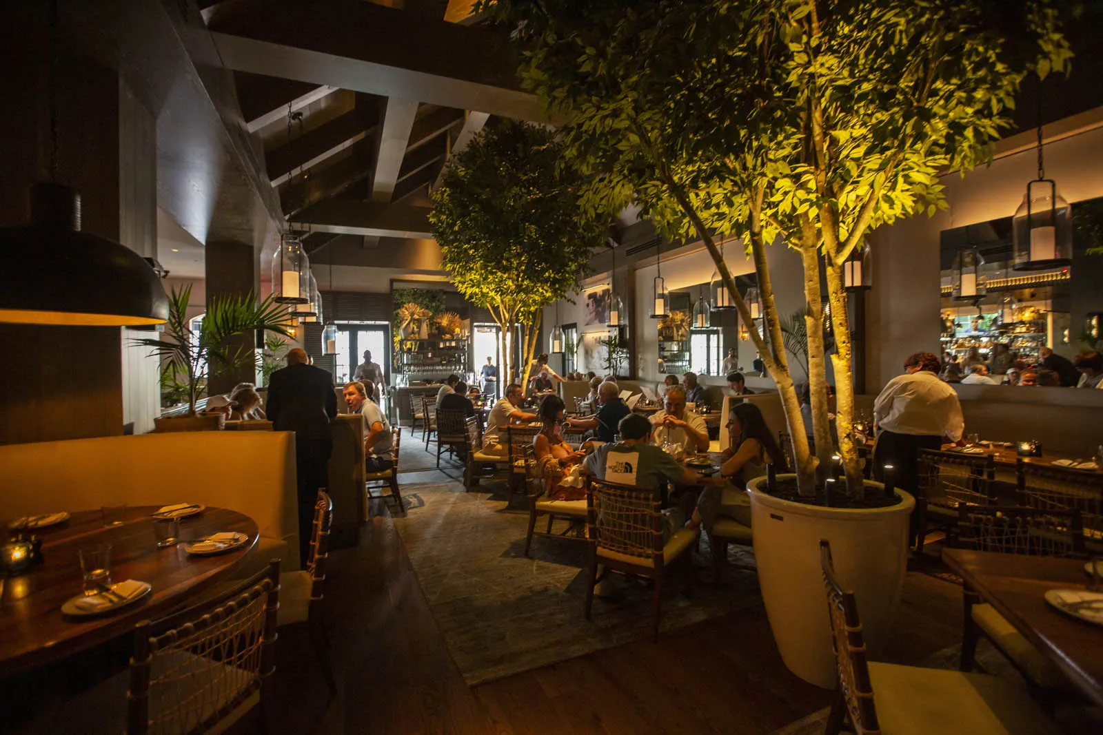 Dining room filled with guests at night at Del Mar Naples restaurant in Florida.