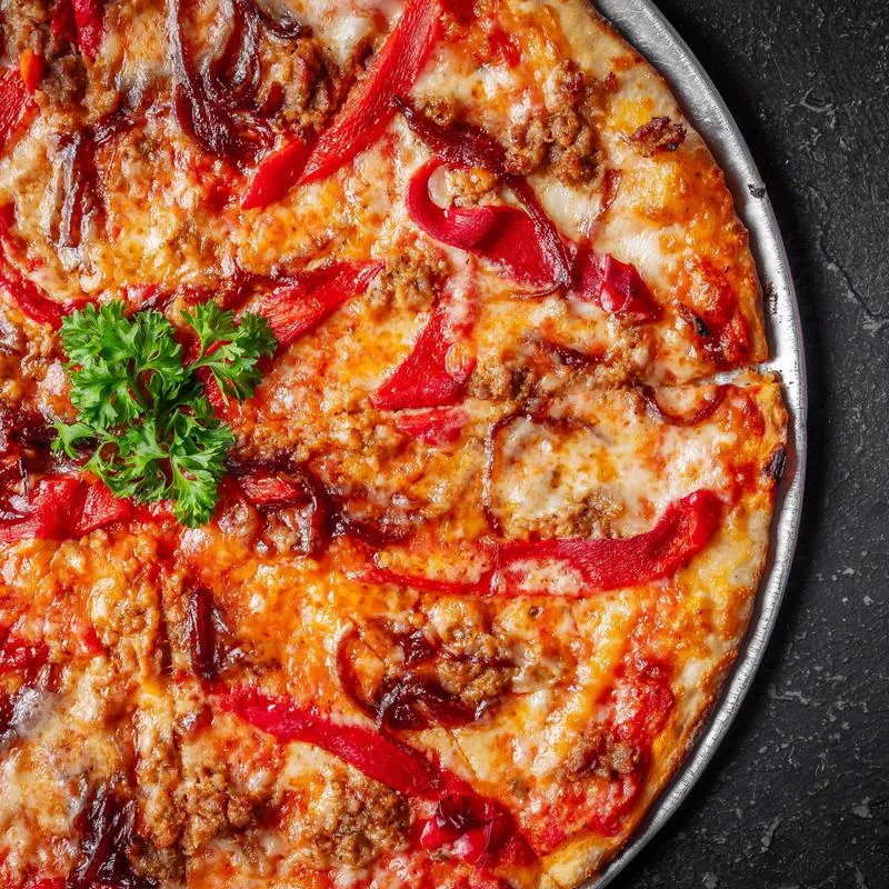Pizza with cheese, sausage, and red peppers.