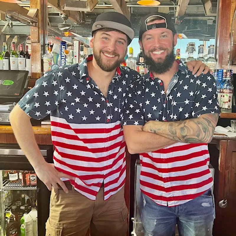 2 bartenders dressed in matching shirts for 4th of July.