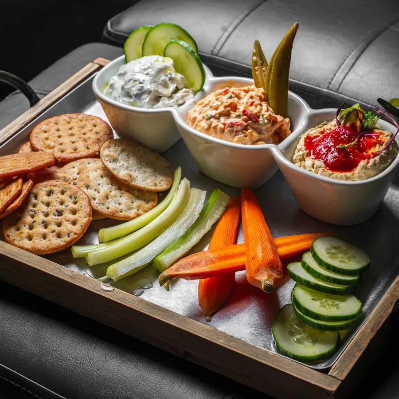 Trio Spread served with artisan crackers and sliced vegetables.