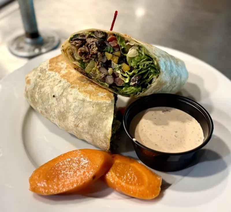 Burrito cut open showing steak, black beans, and fresh vegetables