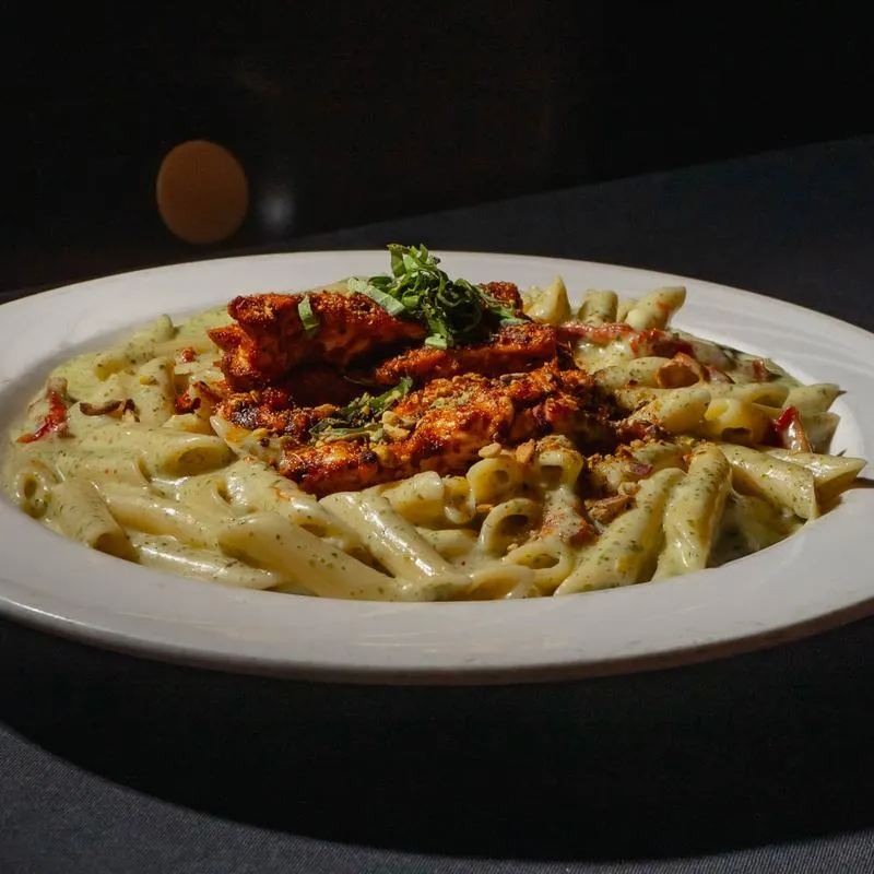 Penne pasta, with blackened chicken, sundried tomato pesto cream sauce, basil, and pistachios.