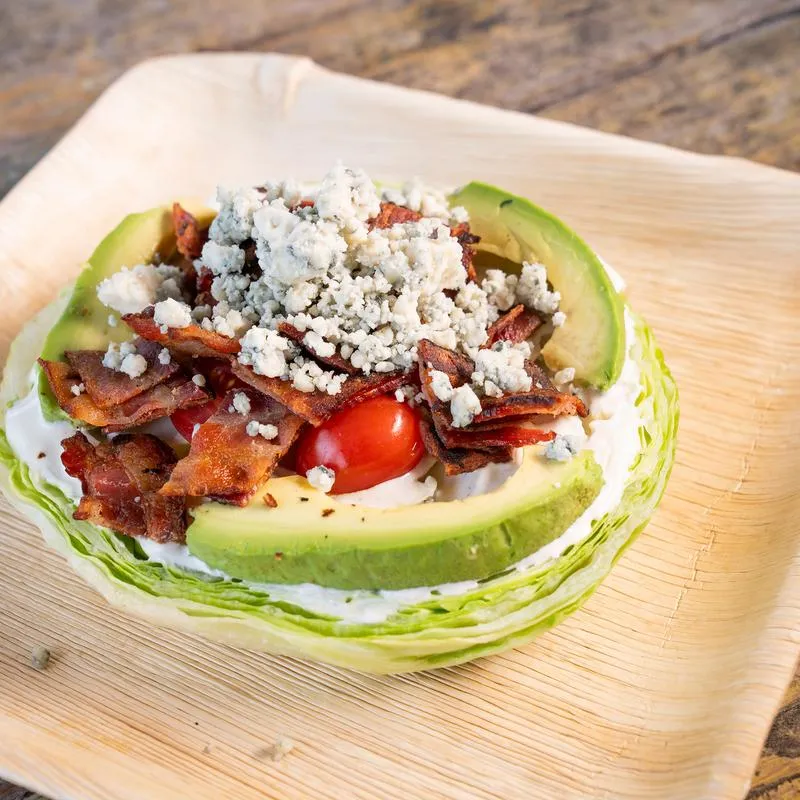 Iceberg Salad with bacon, avocado, cherry tomato and crumbled blue cheese.