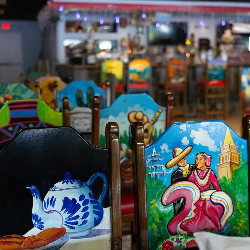 Interior, brightly painted chairs with traditional Mexican motifs.