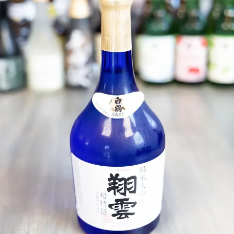 Bottle of sake displayed on the table with sake selection in the background.