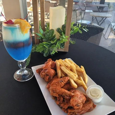 Chicken wings, fries, and a drink.